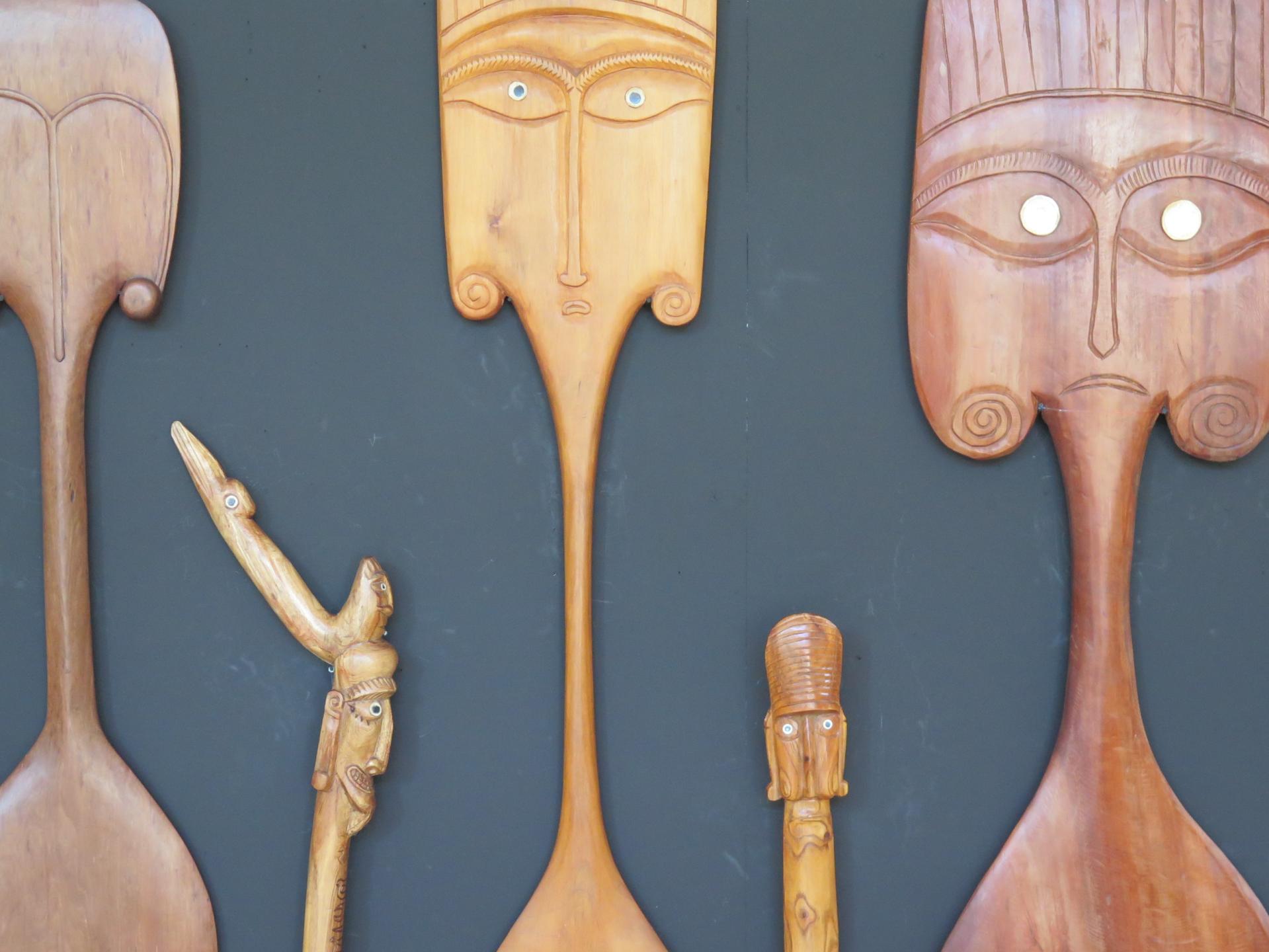 Imagen de remos y bastones tallados en madera.
